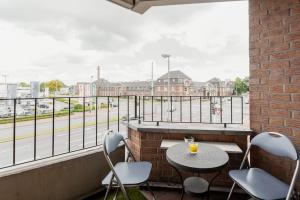 einen Balkon mit einem Tisch und Stühlen sowie Straßenblick in der Unterkunft MaliDu Apartment Krefeld Düsseldorf in Krefeld