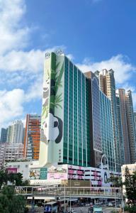 een groot gebouw met een bord erop in een stad bij Panda Hotel in Hong Kong
