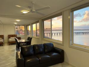 salon z kanapą, stołem i oknami w obiekcie Beachside & Jetty View Apartment 5 - Harbour Master Apt w mieście Streaky Bay