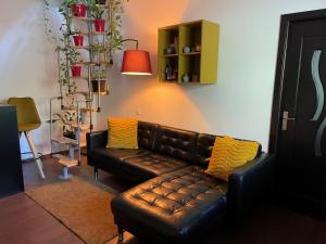 a brown leather couch sitting in a living room at City Garden Apartments in Bucharest