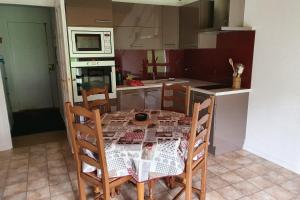 a kitchen with a table with chairs and a microwave at Le Logis de Pimpi in Lamoura