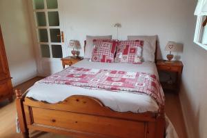 a bedroom with a bed with red and white pillows at Le Logis de Pimpi in Lamoura