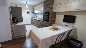 a kitchen with a table with chairs and a television at Dynamic Bike Home in Curtea de Argeş