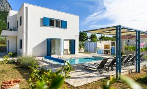 uma villa com uma piscina e uma casa em Holiday home Blue Sky em Zaostrog