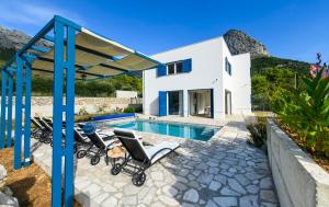 a villa with a swimming pool and a house at Holiday home Blue Sky in Zaostrog