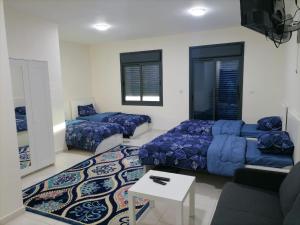 a living room with two beds and a couch at For Women Only - للنساء فقط in Umm el ‘Amad