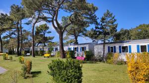 un edificio con árboles delante de él en Camping Paradis Les Galets de la Molliere, en Cayeux-sur-Mer