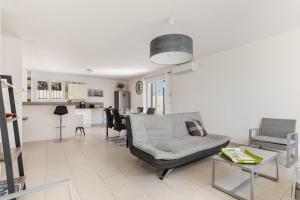 a living room with a couch and a table at Ô Soleil - Avec piscine privée in Vendres
