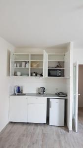 eine weiße Küche mit weißen Schränken in einem Zimmer in der Unterkunft Excellent Apartment M&L in Wien