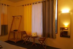 a room with chairs and a table and a window at Firefly Hostel in Manāli