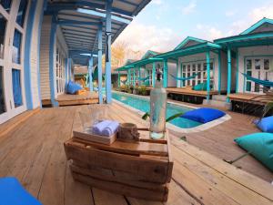 a house with a swimming pool with a wooden deck at Casa Kapuas in Gili Trawangan