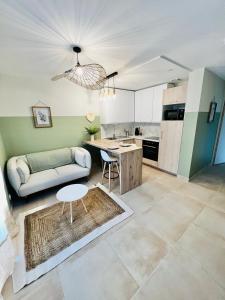 una cucina e un soggiorno con divano e tavolo di Appartement cosy - Trégastel a Trégastel