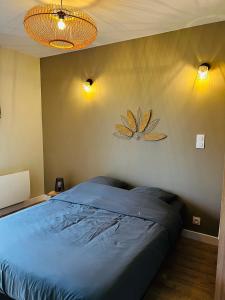 una camera con un letto e due luci sul muro di Appartement cosy - Trégastel a Trégastel