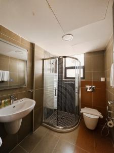 a bathroom with a shower and a sink and a toilet at Celino Hotel in Amman