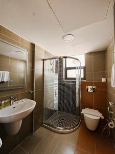 ein Badezimmer mit Dusche, Waschbecken und Toilette in der Unterkunft Celino Hotel in Amman + 46 Fotos
