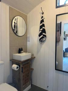 a bathroom with a sink and a mirror at Shepherds Huts in Kidlington