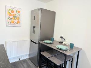 uma cozinha com uma mesa e um frigorífico em Fabulous 2 bed Town house free parking WiFI em Derby