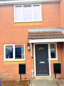 una casa de ladrillo con una puerta y ventanas negras en Fabulous 2 bed Town house free parking WiFI, en Derby