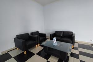 ein Wohnzimmer mit zwei schwarzen Stühlen und einem Tisch in der Unterkunft Hotel Sutha Inn in Jambi