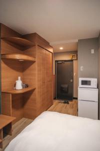 a bedroom with a bed and a kitchen with a microwave at 殿堂 in Tokyo