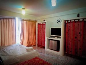 a bedroom with red curtains and a bed and a tv at The Casa Blanca Room condo in Hua Hin