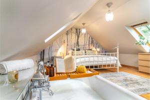 ein Bad mit einer Badewanne und einem Kinderbett im Dachgeschoss in der Unterkunft The Jaw Barn in Milngavie