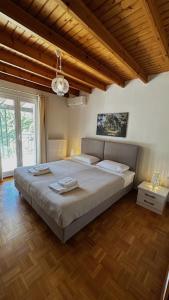 a bedroom with a large bed in a room with wooden floors at Villa Azure in Skiathos