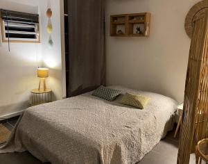 - une petite chambre avec un lit et une lampe dans l'établissement Studio cosy rez de jardin à 10 mn des plages, à Baie-Mahault