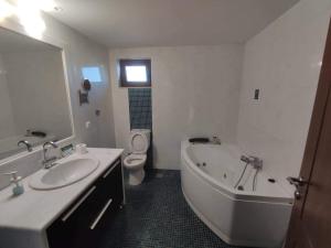 a bathroom with a sink and a tub and a toilet at Serapis Country House on the hill above Heraklion Off grid in Archanes