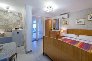 a bedroom with a large bed and a bathroom at Apartments Nadica in Baška