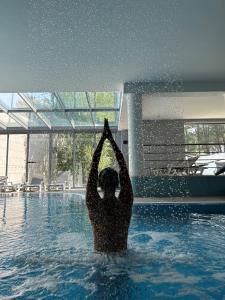 uma pessoa na água fazendo yoga em uma piscina em Monte Prado Hotel & Spa em Melgaço