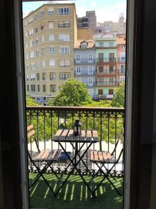 Una habitación en mi casa - Centro de Santander في سانتاندير: طاولة وكراسي على شرفة مطلة على مدينة