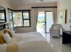 een slaapkamer met een groot wit bed en een stoel bij The Executive 5 Bedroom in Manzini