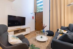 a living room with two couches and a flat screen tv at DormForYou Alameda 12 Apartment in Valencia