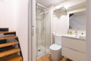 a bathroom with a toilet and a glass shower at DormForYou Alameda 12 Apartment in Valencia