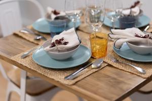 una mesa de madera cubierta con placas azules y cubiertos en DormForYou Alameda 12 Apartment, en Valencia