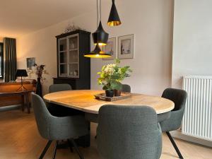 una sala da pranzo con tavolo e sedie in legno di High Street Haven a Eindhoven