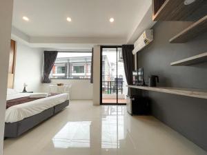 a bedroom with a bed and a television on a wall at Kefir Phuket in Kamala Beach