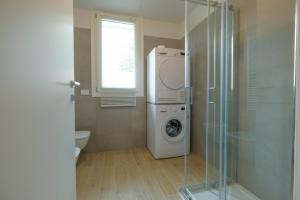 a bathroom with a washing machine and a glass shower at BergamoCityCenter 01 in Bergamo