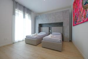 1 dormitorio con 2 camas y un cuadro en la pared en BergamoCityCenter 01, en Bérgamo