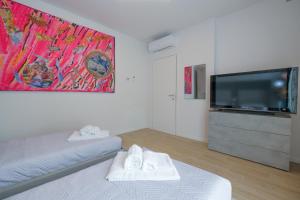 Habitación con 2 camas y TV de pantalla plana. en BergamoCityCenter 01, en Bérgamo