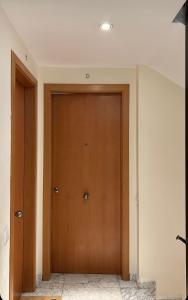un pasillo con una puerta de madera en una casa en M1 Céntrico y con balcón, en Terrassa