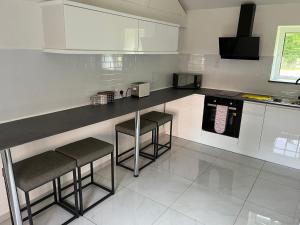 a kitchen with a counter and stools in it at Yu’s Guest House in Sevenoaks