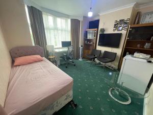 a bedroom with a bed and a desk and chairs at Double room in Canvey