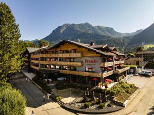 a large hotel with mountains in the background at Hotel Franks in Oberstdorf