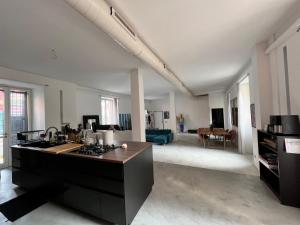 a kitchen and living room with a stove top oven at La casa di Wayne in Cologno Monzese