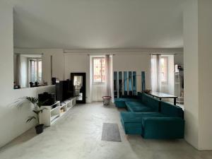 sala de estar con sofá azul y TV en La casa di Wayne, en Cologno Monzese