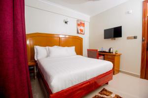 a bedroom with a bed and a red curtain at HADJENS HOTEL in Mwanza +6 photos
