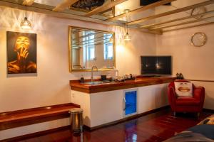 a room with a bar with a sink and a tv at B&B Katoo in Linne