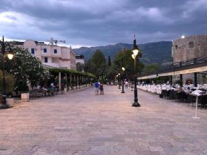 une rue avec des tables et des chaises et un éclairage de rue dans l'établissement Budva Morska oaza, à Budva